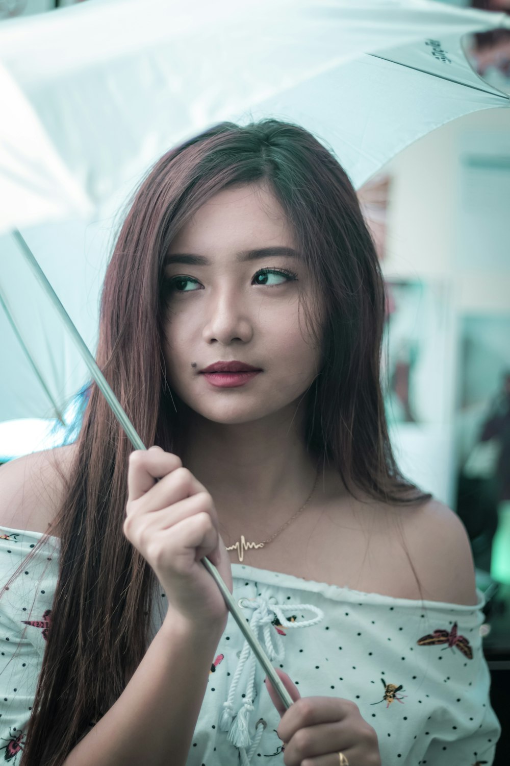 woman holding gray and white umbrella