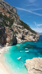 gray and green mountain beside sea during daytime