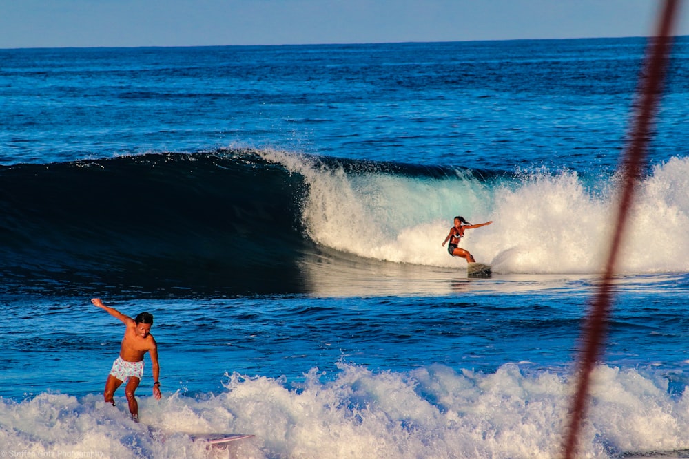 woman doing stunt on surfboard during daytime