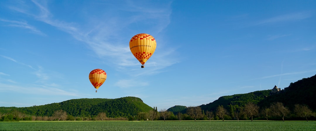 two hot air balloons flying above ground