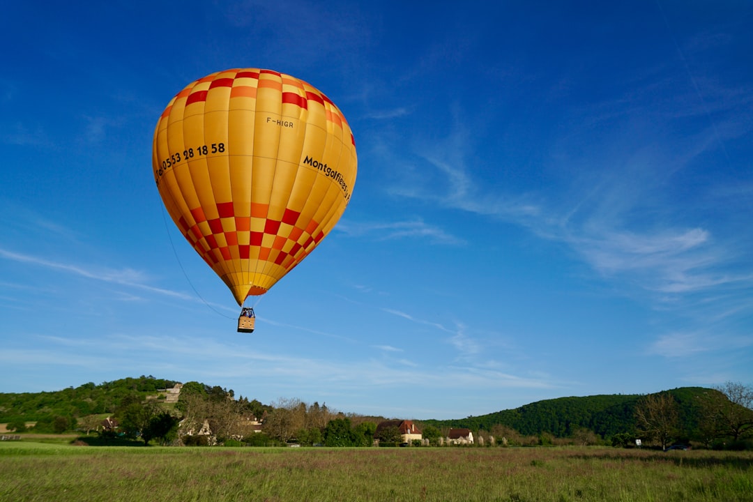 hot air balloon flying above houses