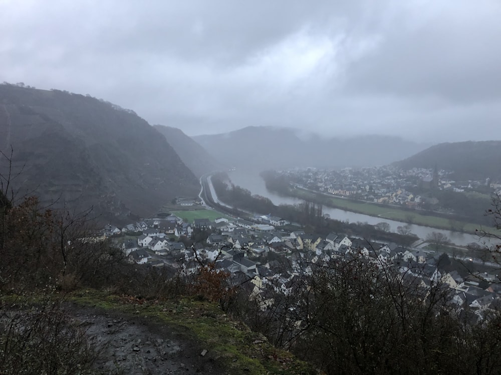 mountain near body of water during foggy weather