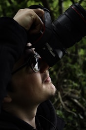 Portrait of a focused photographer at work capturing natural light in an outdoor setting.