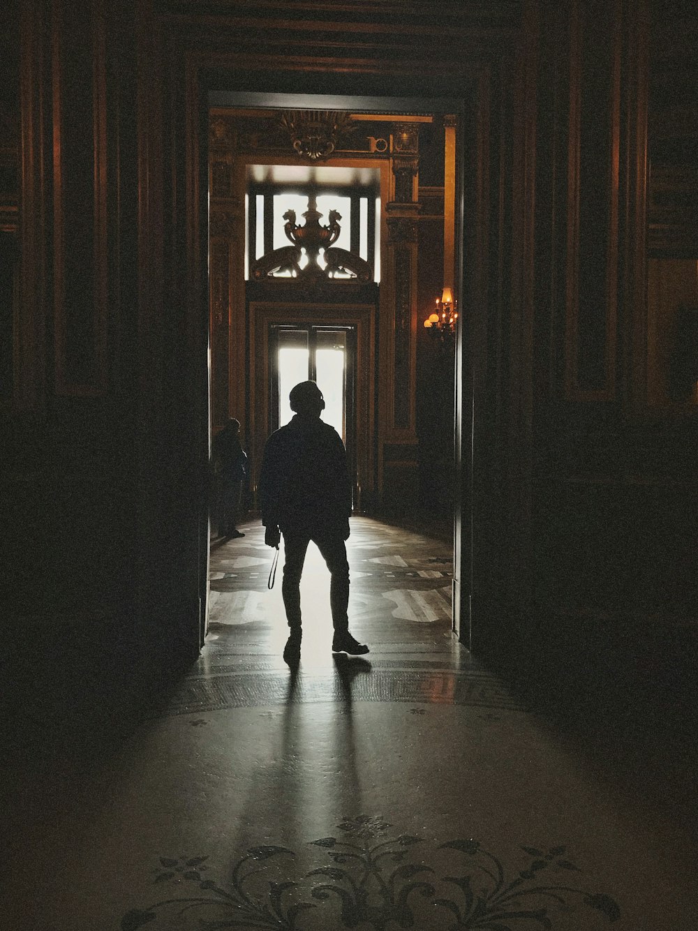 a person standing in a doorway with a skateboard