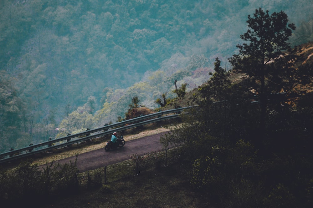 person riding motorcycle in road during daytime top-view photography