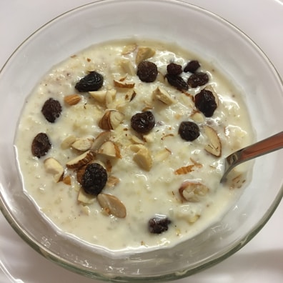 Creamy shrikhand served in a bowl garnished with saffron strands and pistachios.