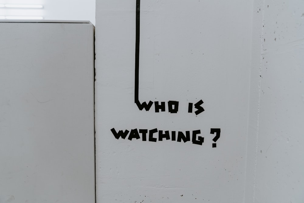 누가 보고 있다고 적힌 검은색 스티커가 붙은 흰색 냉장고?