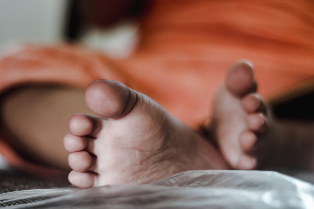 a close up of a person's bare feet on a bed