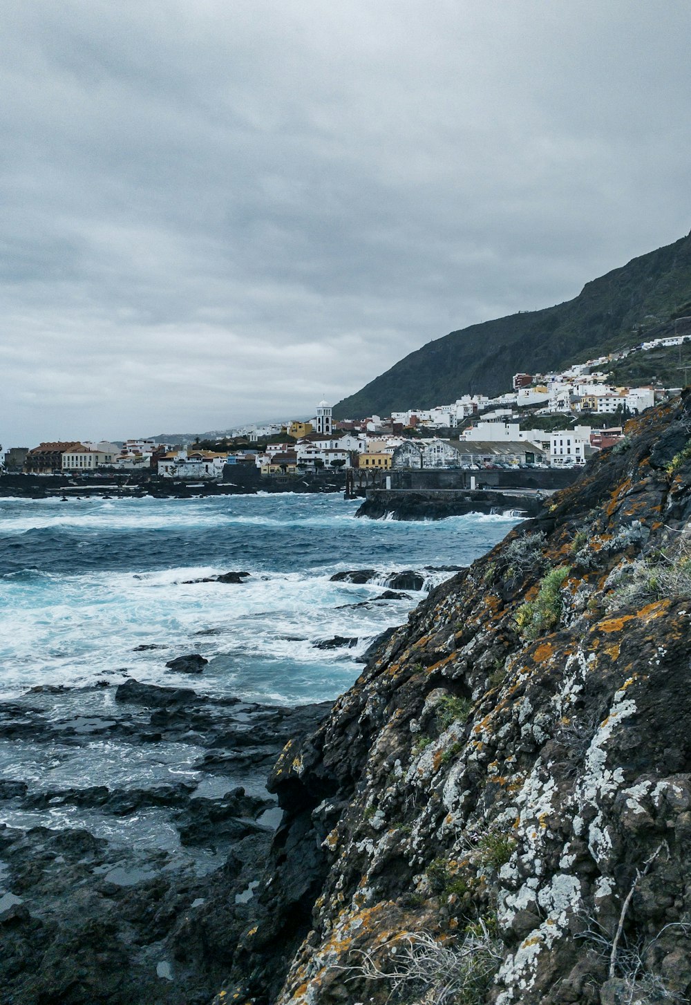 concrete buildings near seashore under gray clouds during daytime