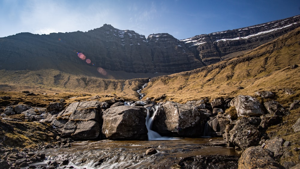 creek flowing from hill to barren valley