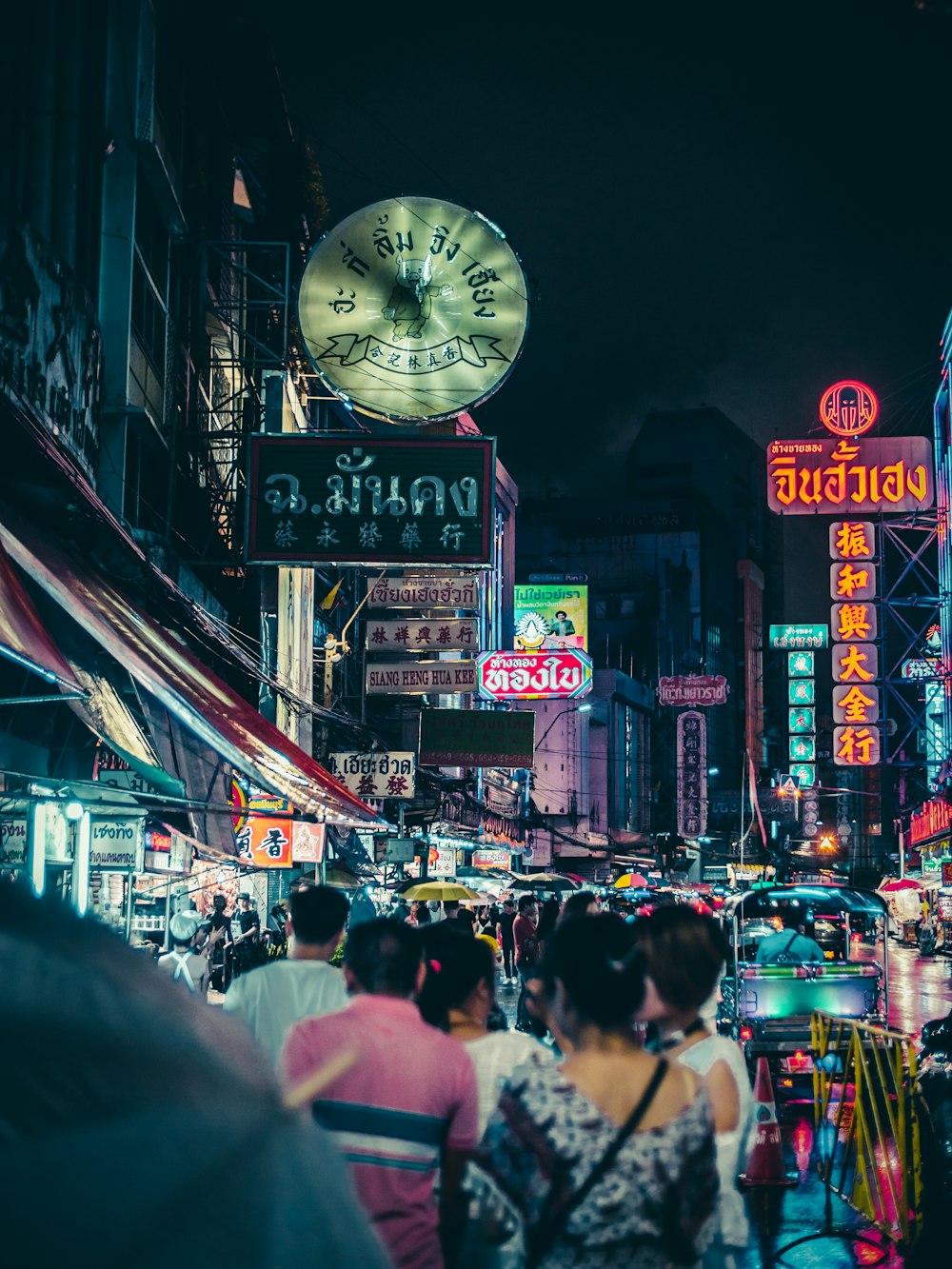 a crowded city street at night with neon signs