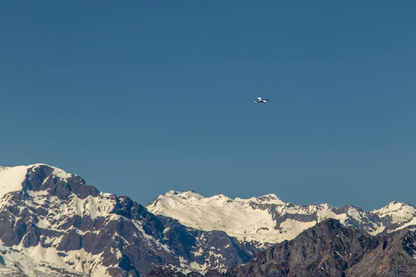 A small plane flying low over the vast glaciers of southern Chile under a clear blue sky.