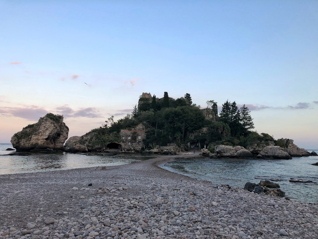 rock formation near calm body of sea,