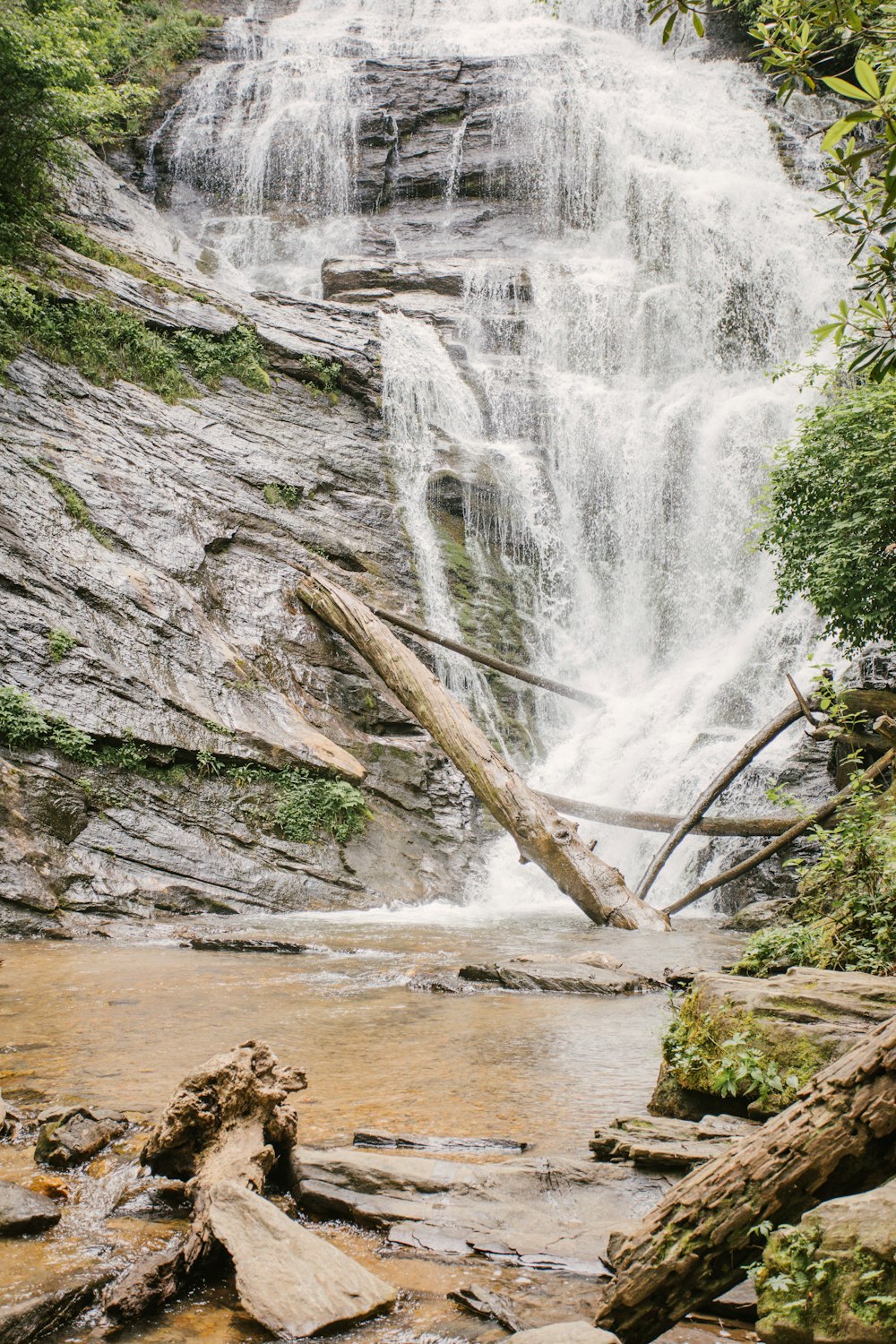 water falls on brown rocky shore during daytime