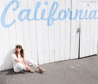 woman sitting on floor while leaning on wall