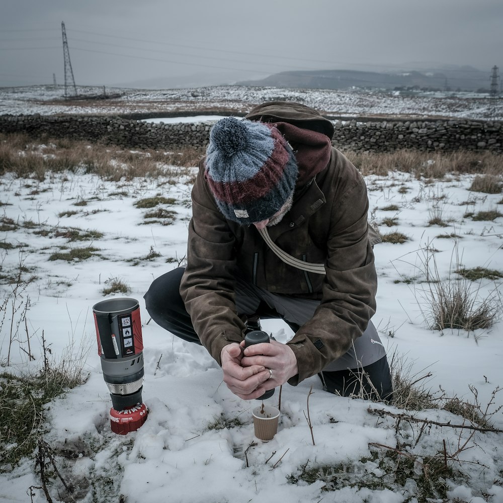 man kneeling on snow field