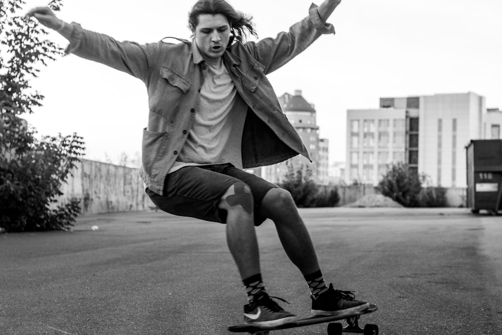 grayscale photography of man playing skateboard