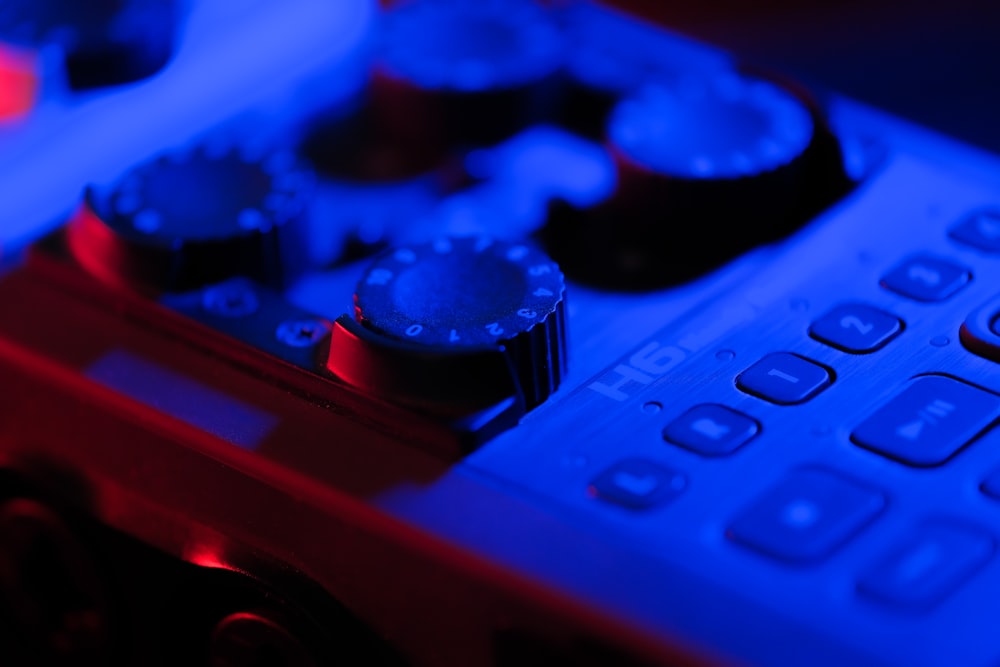 a close up of a remote control with blue light