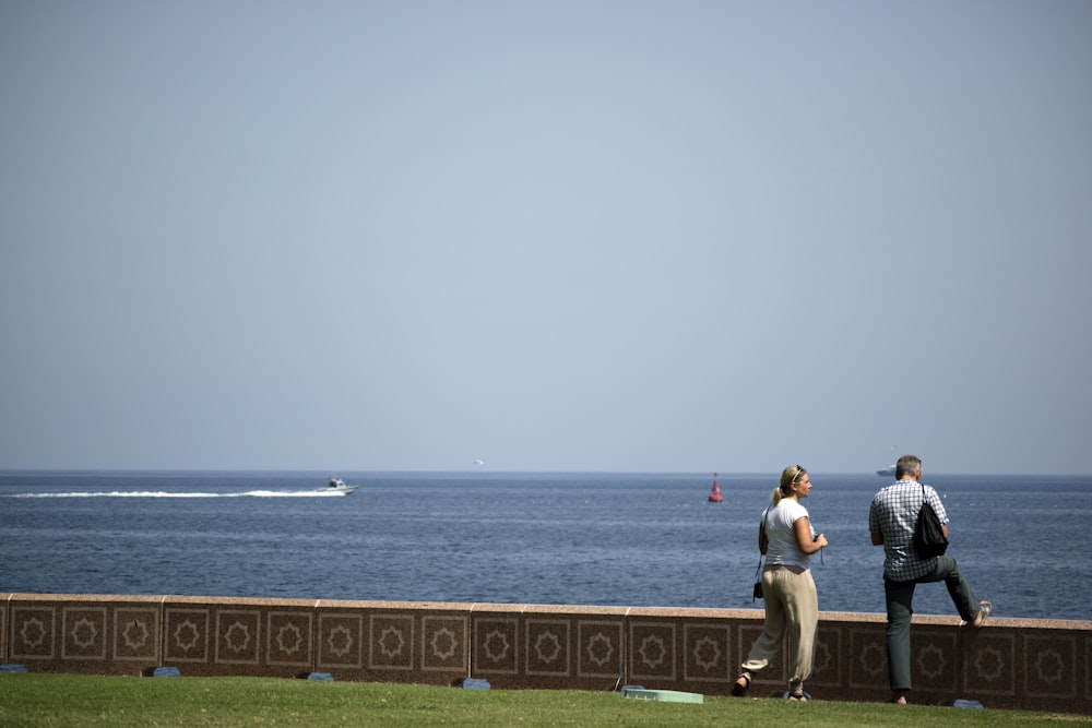 two people standing near body of water