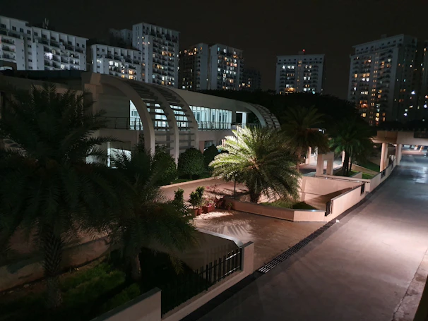 Nighttime shot of a well-lit residential development project highlighting modern architectural lines and ongoing work.