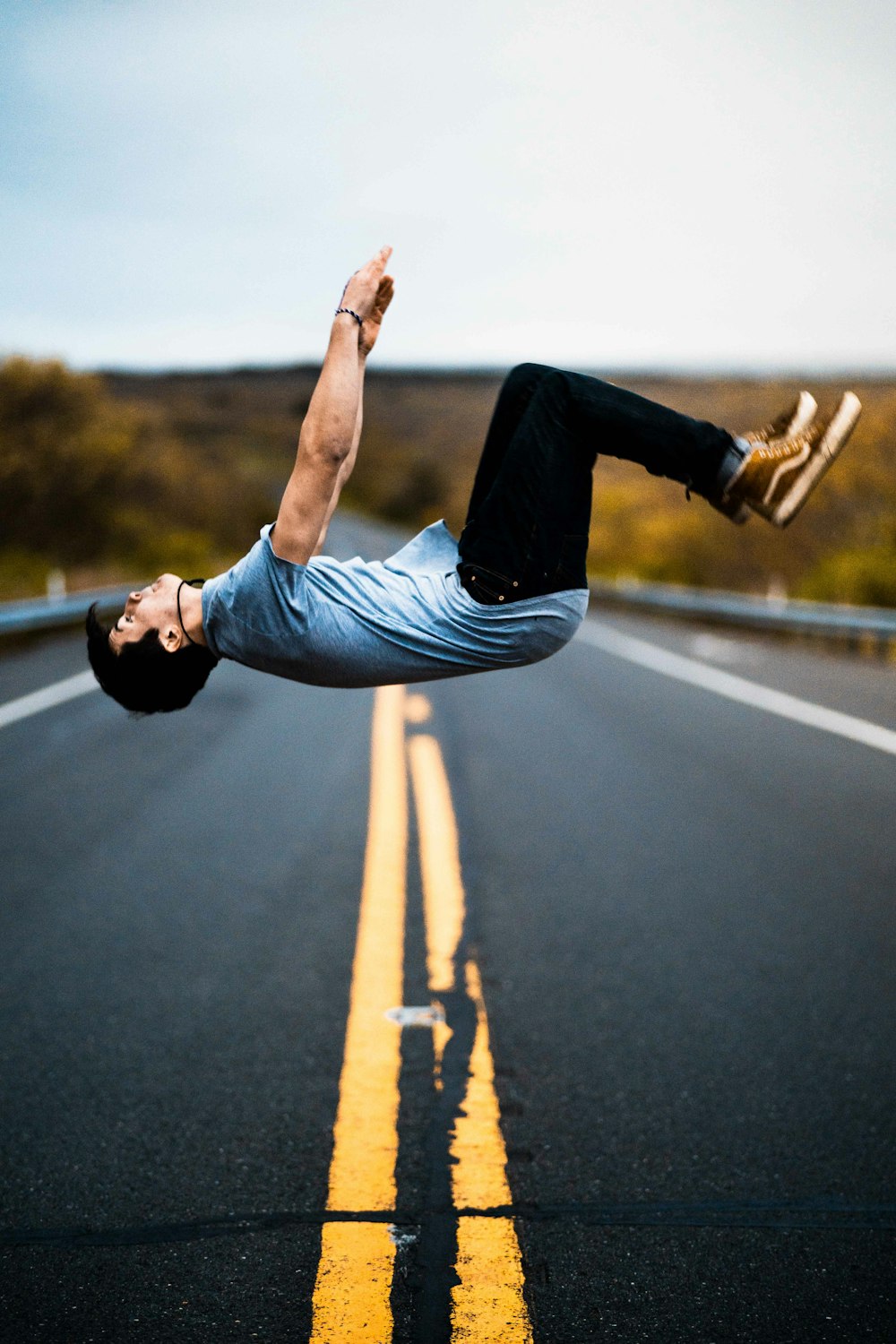 man backflipping in the middle of the road