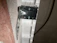 Close-up of a stainless steel corner bracket securely attached to a wooden furniture corner.