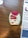 A medication inhaler labeled 'Anoro Ellipta' is placed on a wooden surface. The inhaler has a red and white design with clear dosage instructions and a counter displaying the number '12'. Beside it, part of a paper or booklet with informational text is visible.