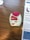 A medication inhaler labeled 'Anoro Ellipta' is placed on a wooden surface. The inhaler has a red and white design with clear dosage instructions and a counter displaying the number '12'. Beside it, part of a paper or booklet with informational text is visible.