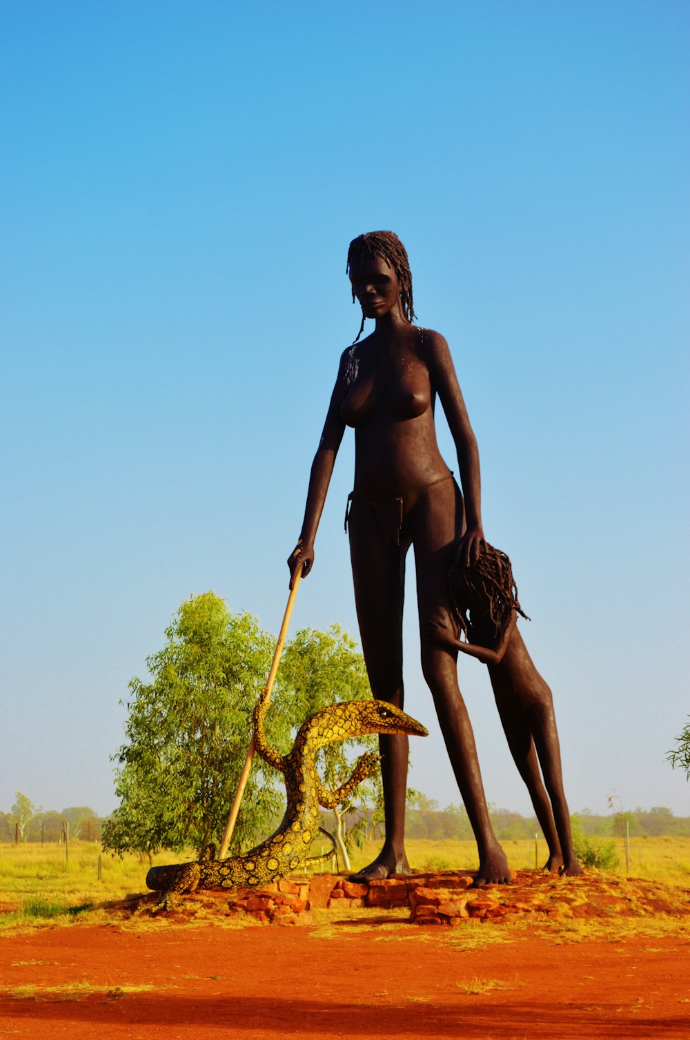 woman beside child while holding cane statue