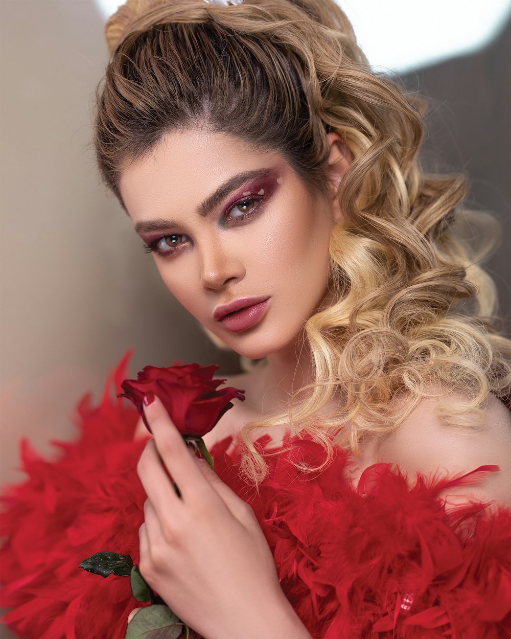 close-up photography of woman holding red rose flower