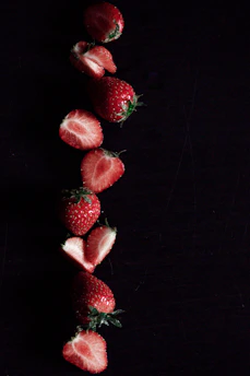 Close-up of vibrant freeze-dried strawberry crisps arranged artistically on a white background.