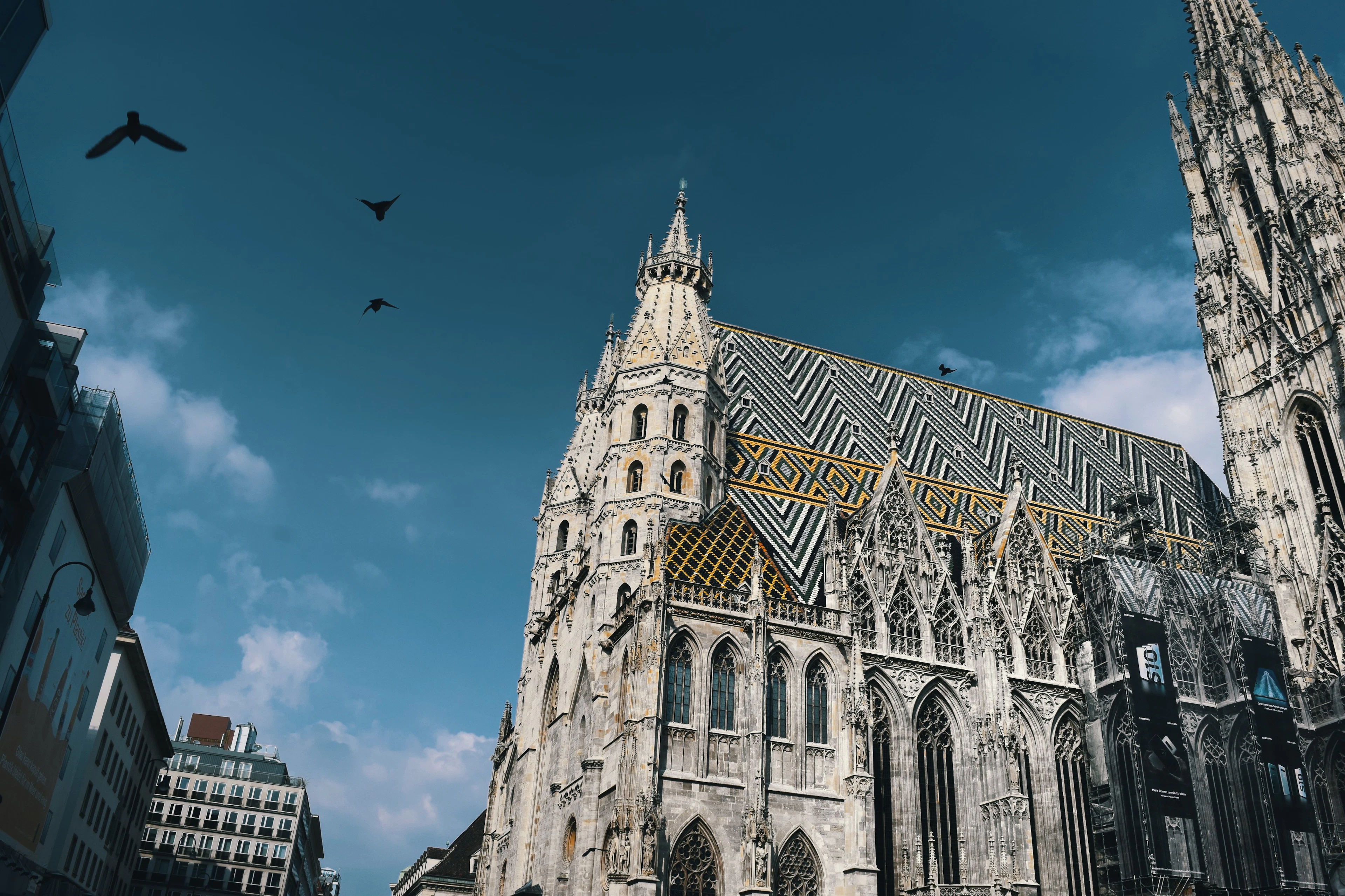 St Stephen's Cathedral in Vienna from below, its Gothic stonework and chevroned roof against a blue sky