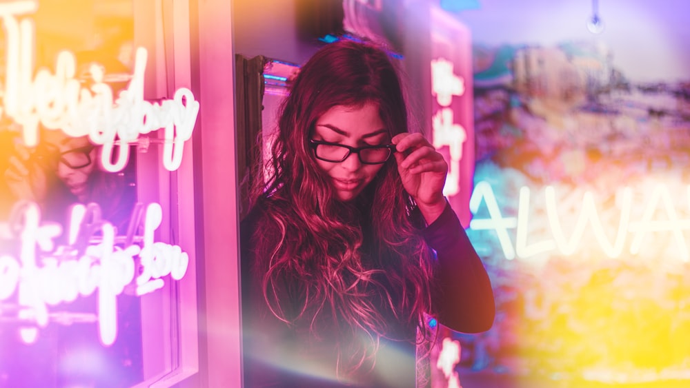 woman standing beside neon light signage