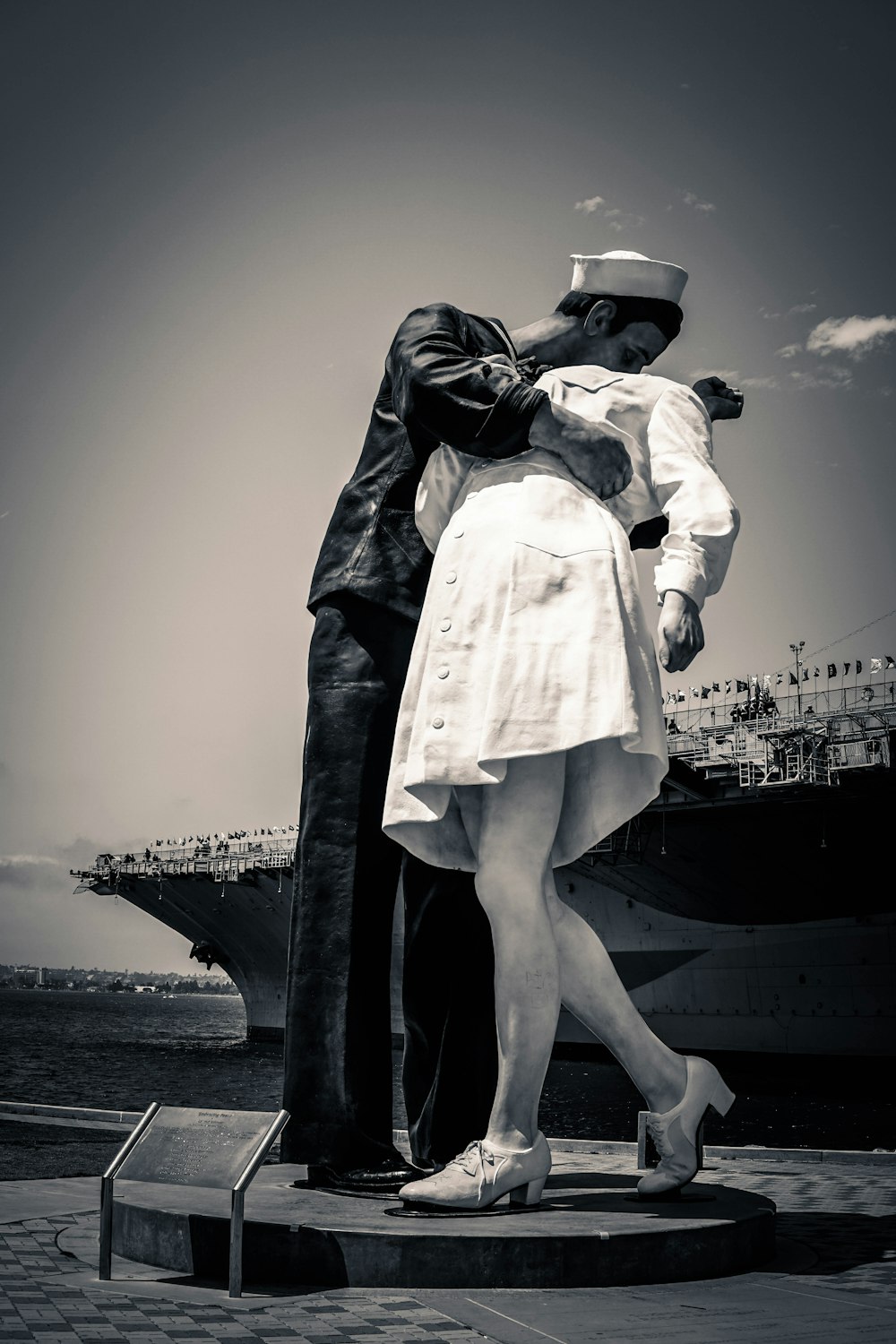 grayscale photo of man kissing woman statue