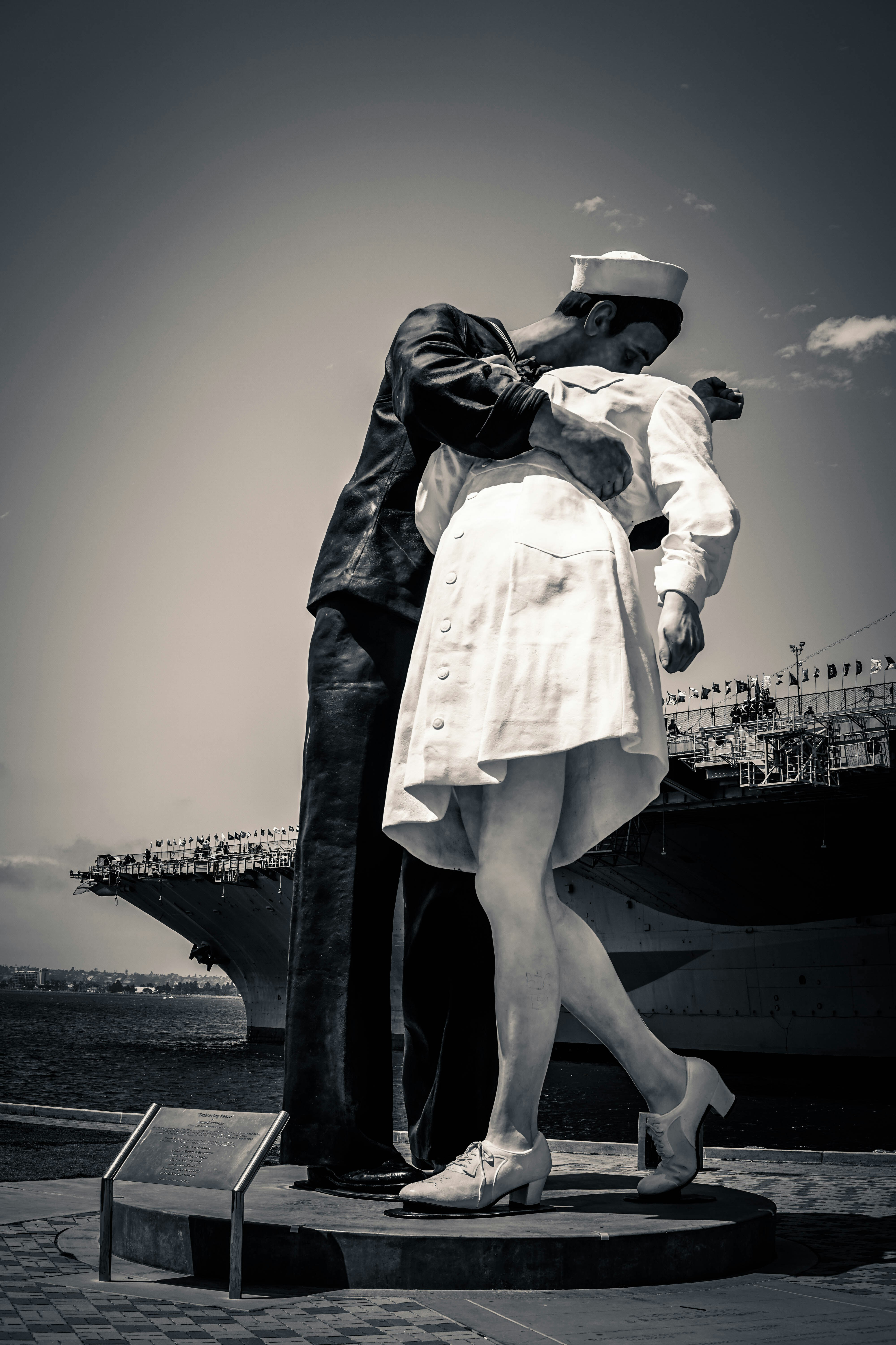 grayscale photo of man kissing woman statue