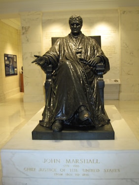 Portrait of Robert M. Marshall in his office, surrounded by law books and case files.