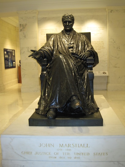 Portrait of Robert M. Marshall in his office, surrounded by law books and case files.