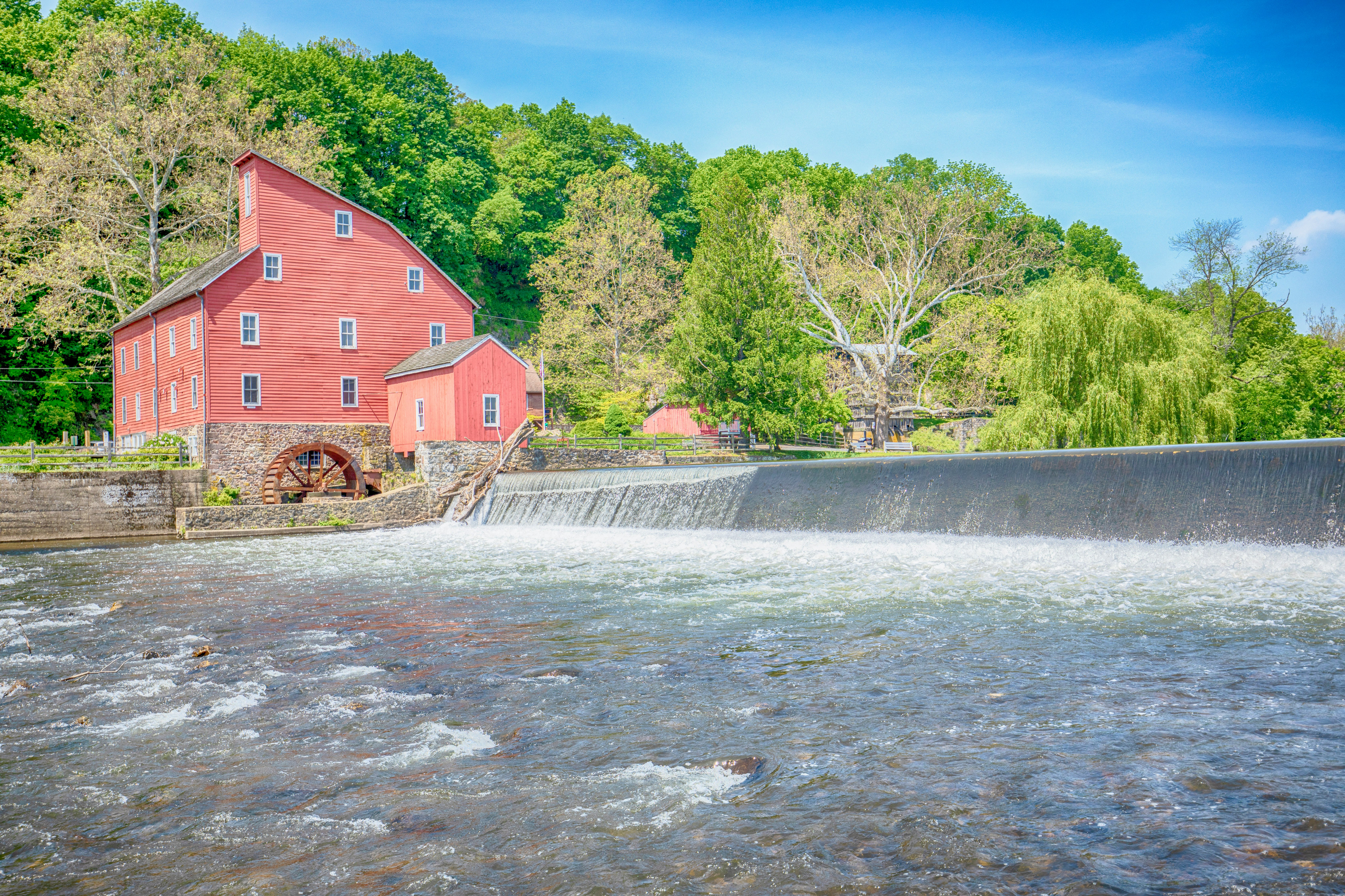 red barn near body of water during daytime