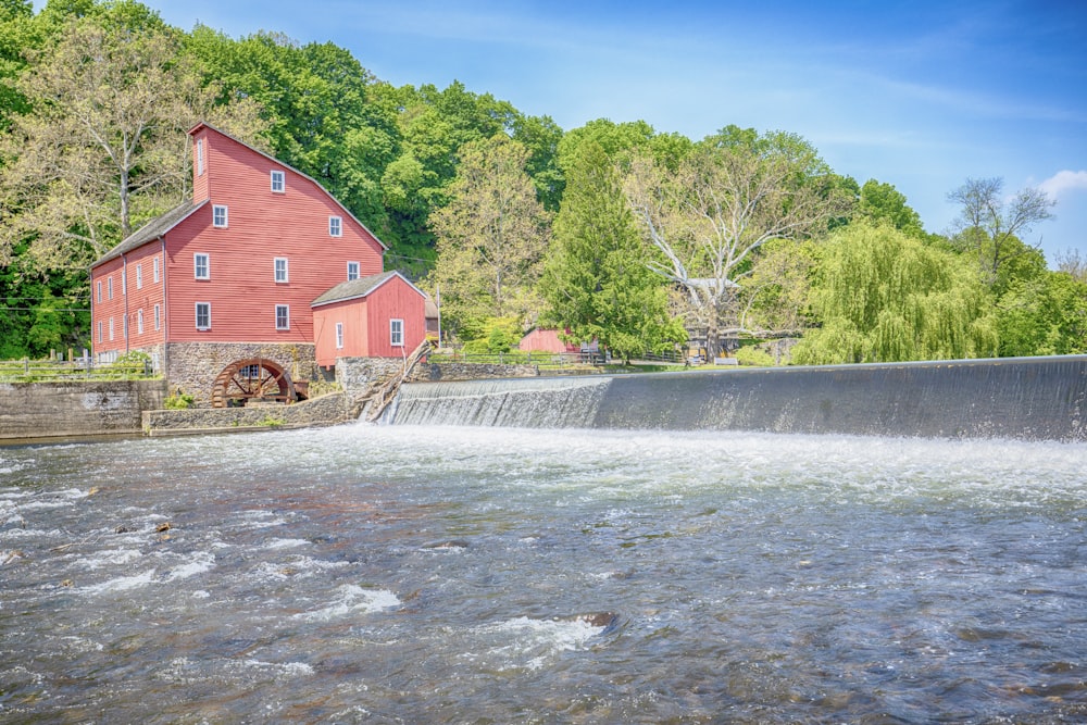 red barn near body of water during daytime