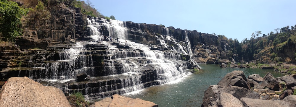 waterfall surrounded with trees during daytime