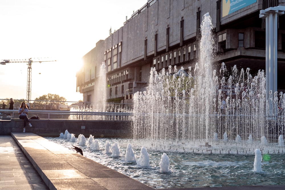 Frau sitzt am Brunnen