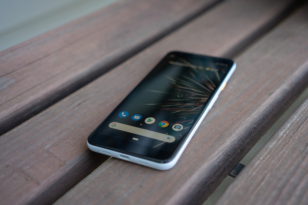 white and black smartphone on brown wooden chair