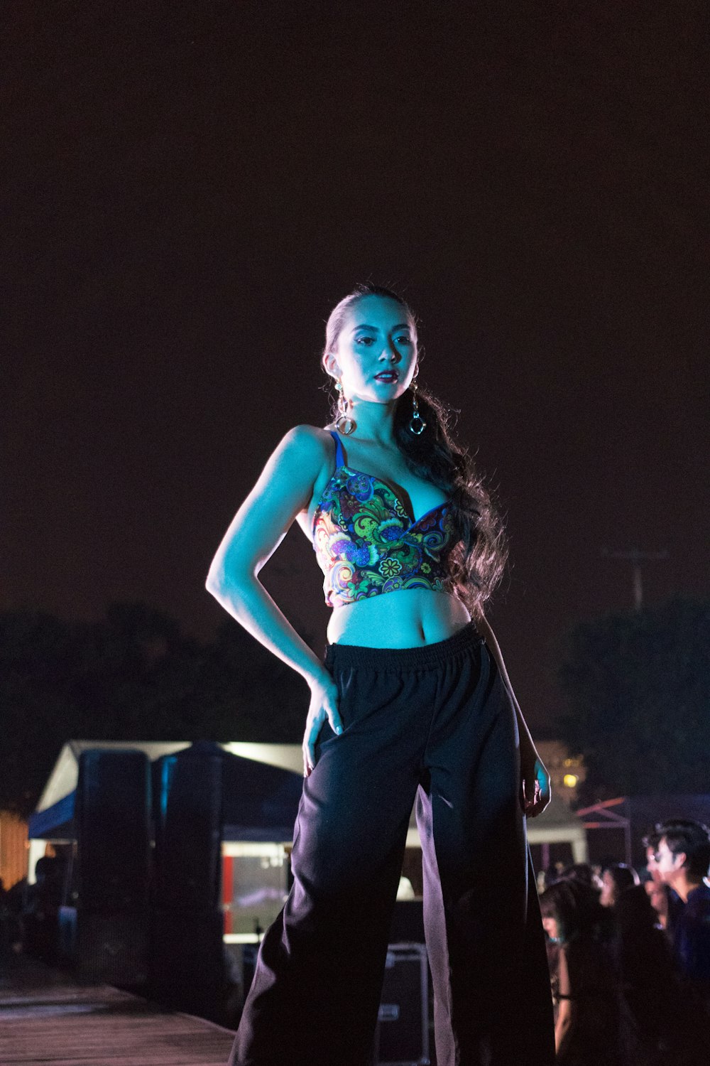 woman standing near two PA speakers during nighttime