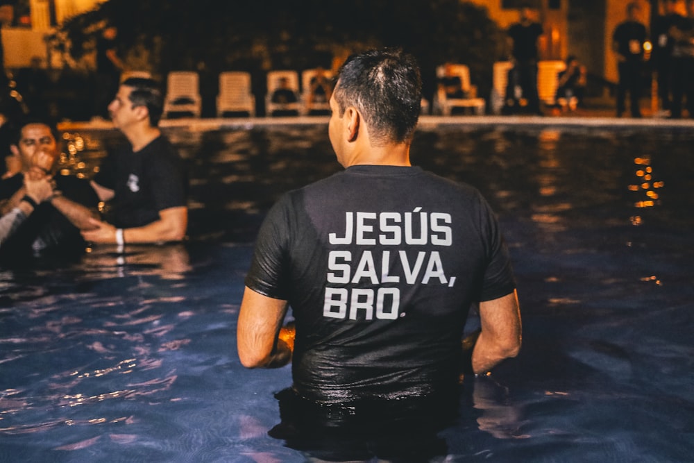 man wearing black t-shirt standing in pool