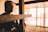 Close-up of hands holding a small wooden cross with soft natural lighting.
