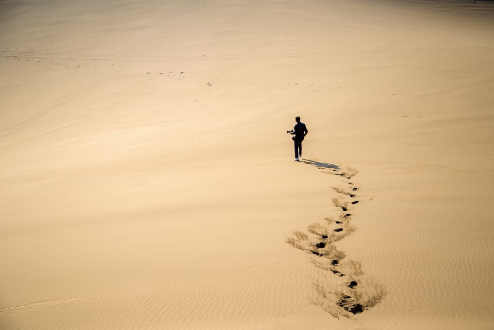 man walking on desert during daytime
