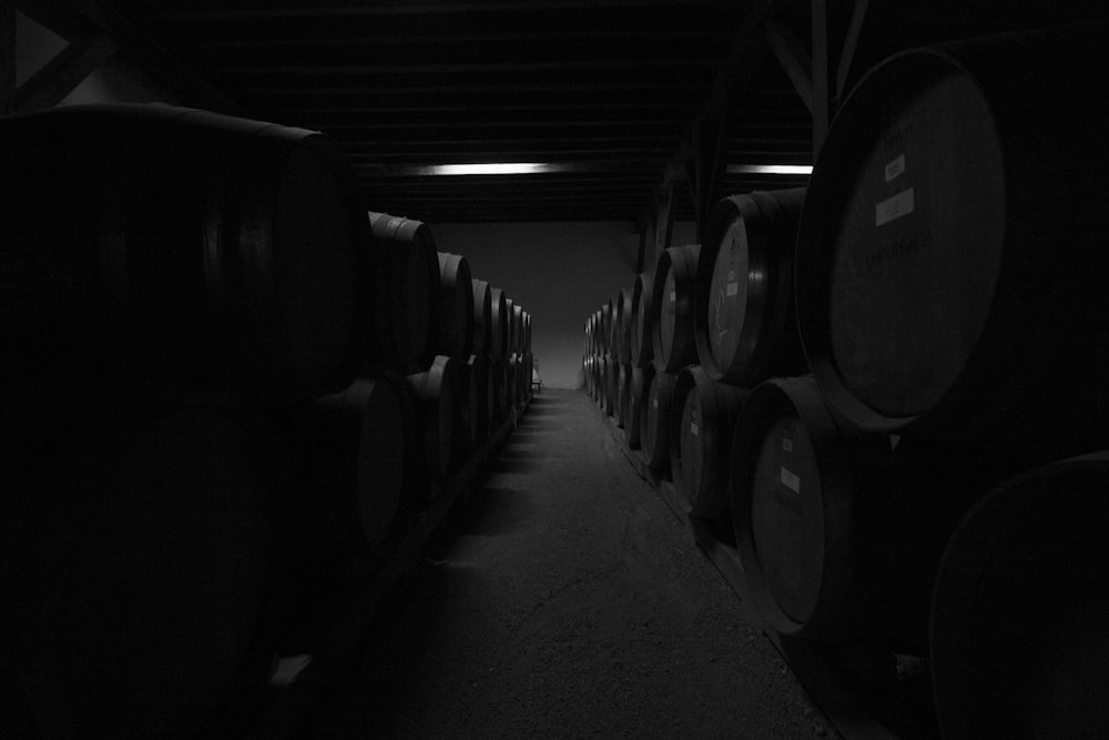 a row of wine barrels in a dark room