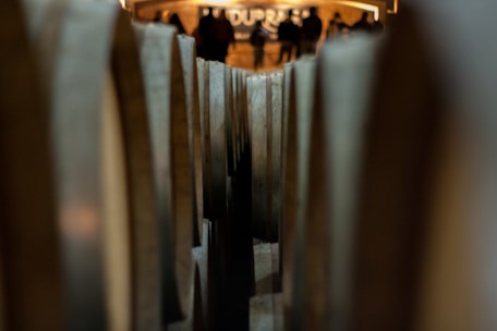Close-up of artisanal cachaça bottles with wooden barrels in the background.