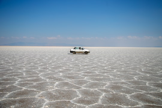 white sedan on dirt field during day in Isfahan Province Iran