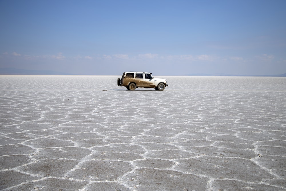 brown SUV on gray sand